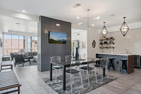 A modern dining room with a glass table and chairs.