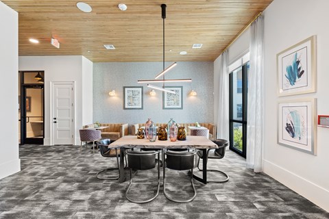 A dining room with a table set for six people.