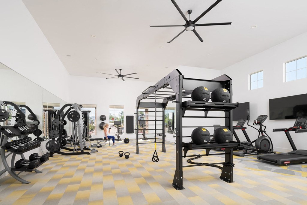 A person is working out in a spacious gym with a variety of equipment.