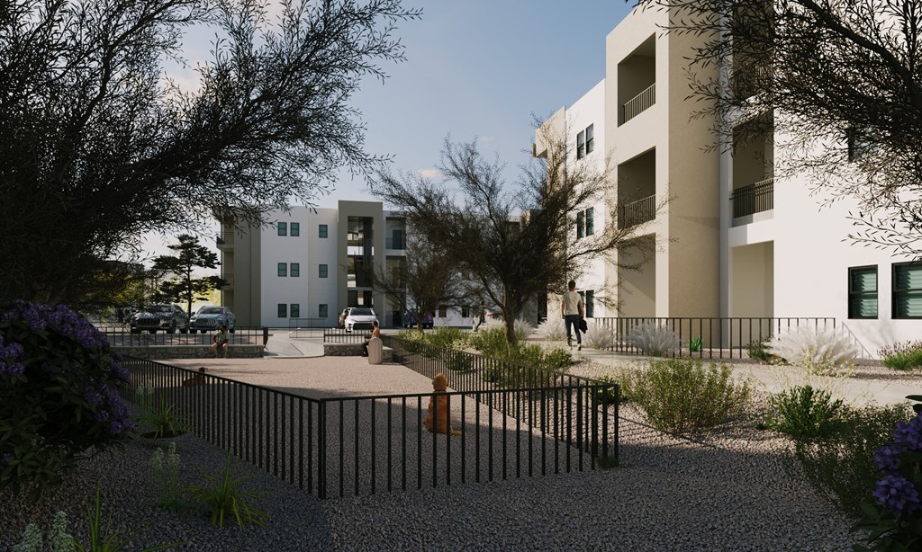 a fenced in area with a fire hydrant in front of some buildings