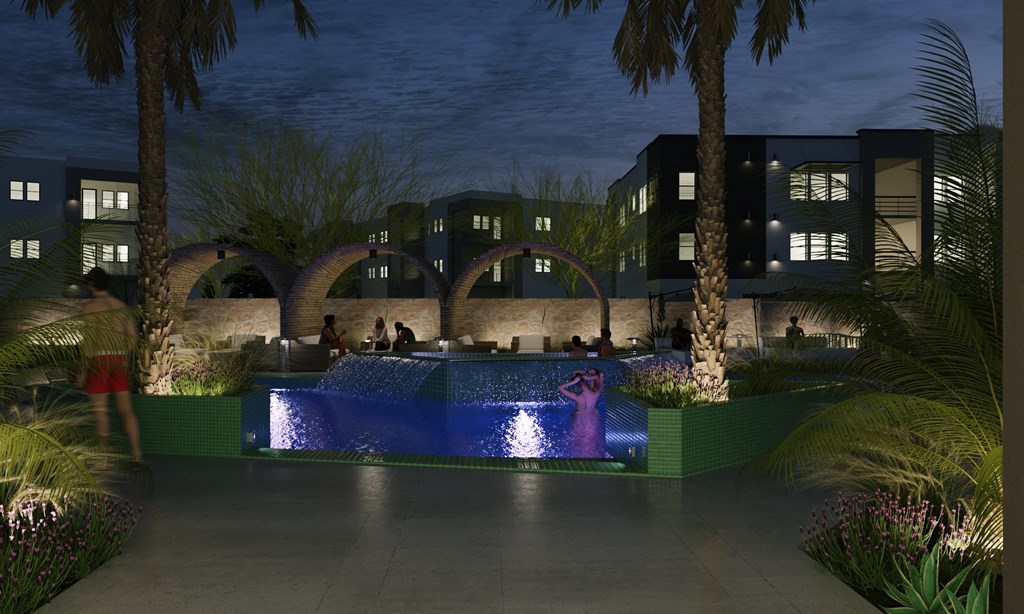 an outdoor pool at night with palm trees and buildings in the background