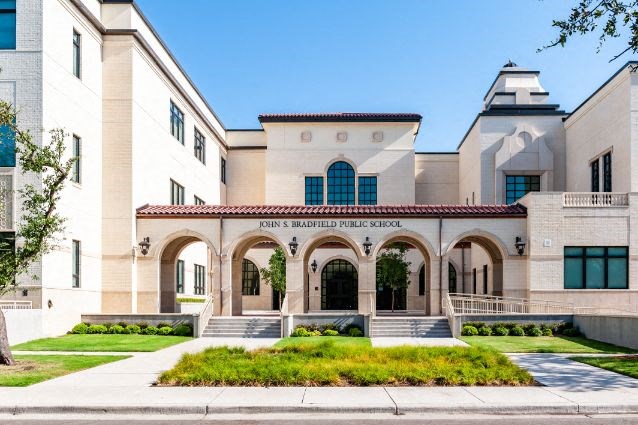 the front of a building with a sidewalk and grass