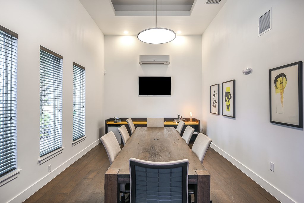 A conference room with a long table and chairs.