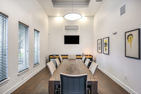 A conference room with a long table and chairs.