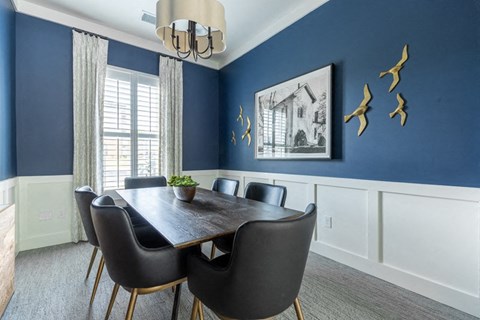 a dining room with blue walls and a table and chairs