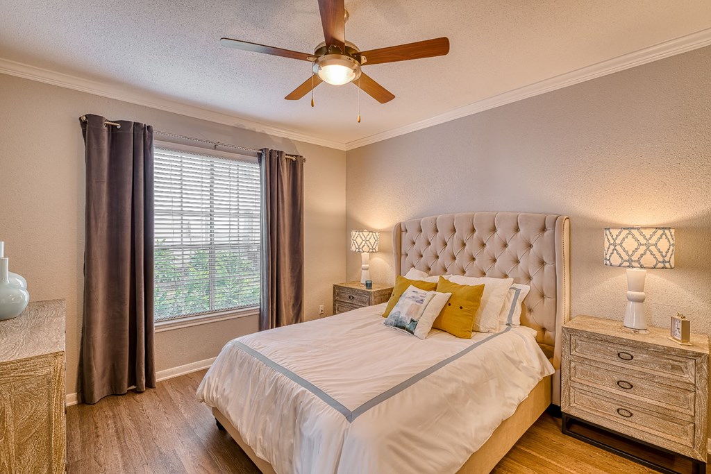 a bedroom with a large bed and a ceiling fan