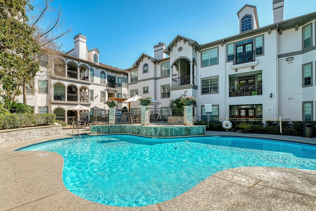 a swimming pool in front of an apartment building with a pool