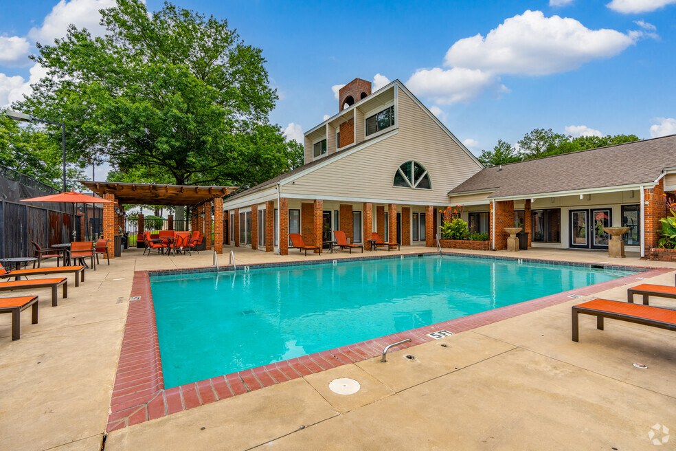 a swimming pool in front of a house with a resort style pool