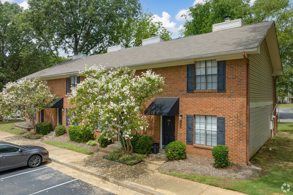a brick house with a tree in front of it