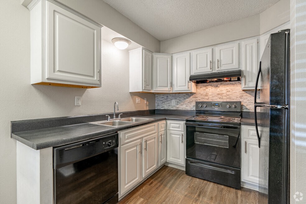 a kitchen with black appliances and white cabinets