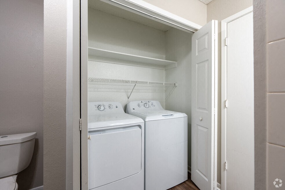a white laundry room with two washes and a toilet