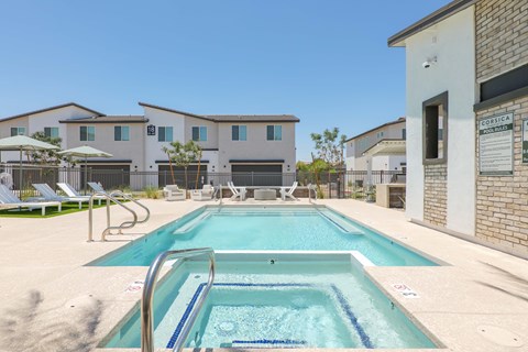 A pool in front of a building with a sign that says "Corsica".