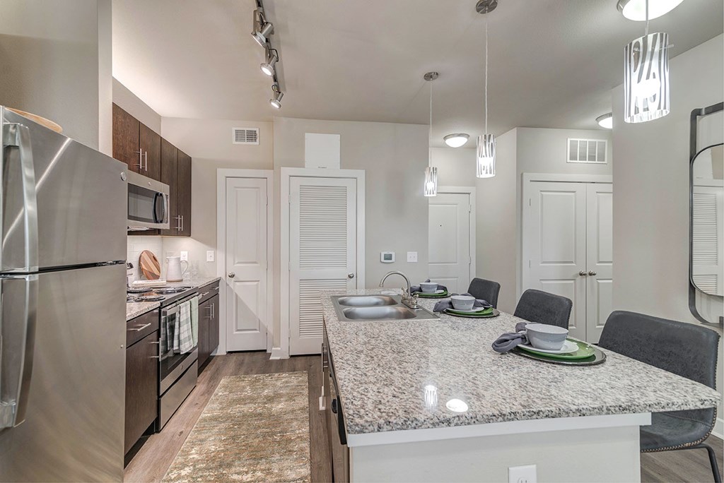 A kitchen with a granite countertop and a refrigerator.