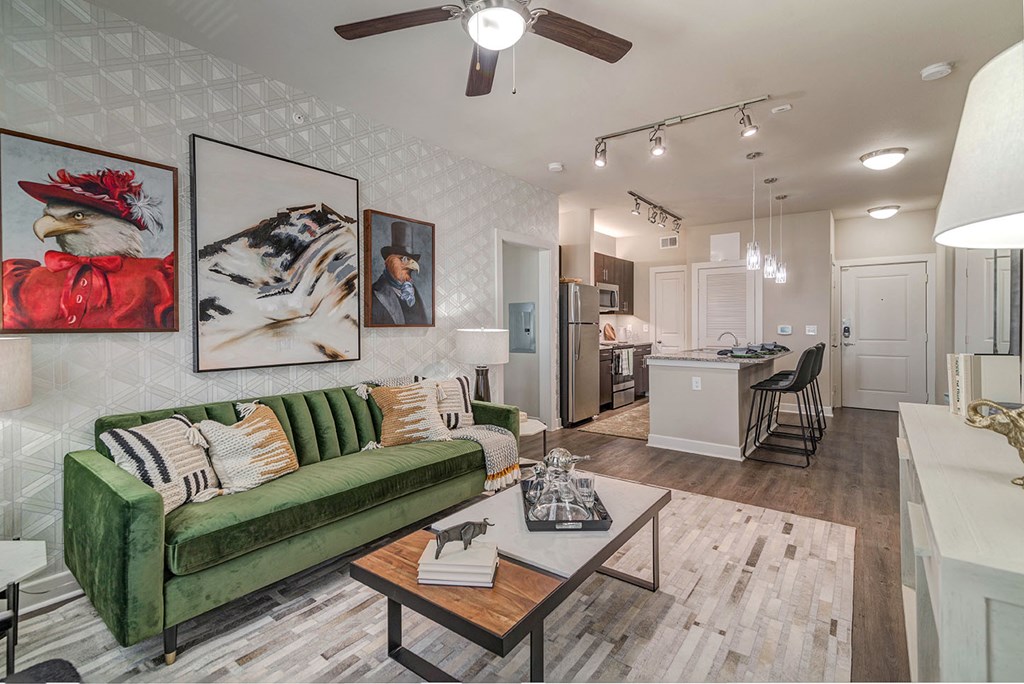 A living room with a green couch and a ceiling fan.
