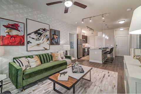 A living room with a green couch and a ceiling fan.