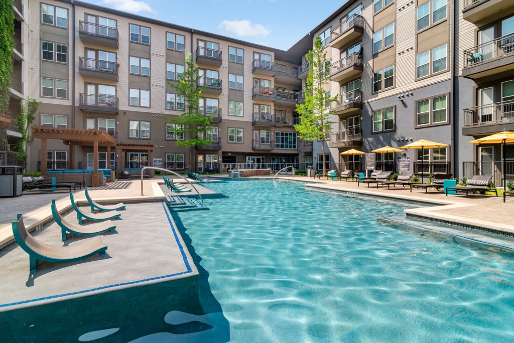 A large swimming pool in front of apartment buildings.