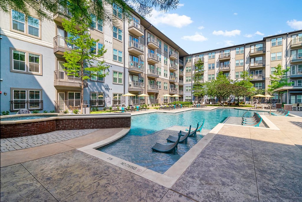 A large swimming pool in front of apartment buildings.