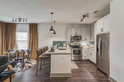 A modern kitchen with a dining table and chairs.