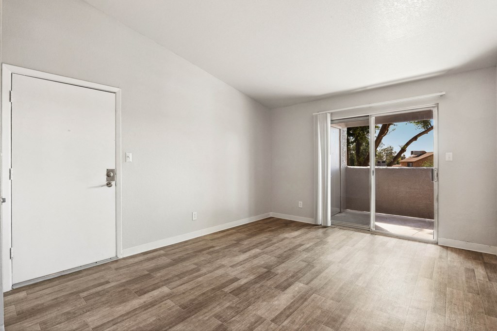 an empty living room with a door to a patio