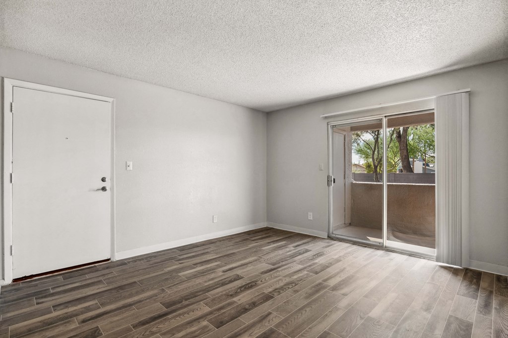 an empty living room with a sliding glass door to a patio