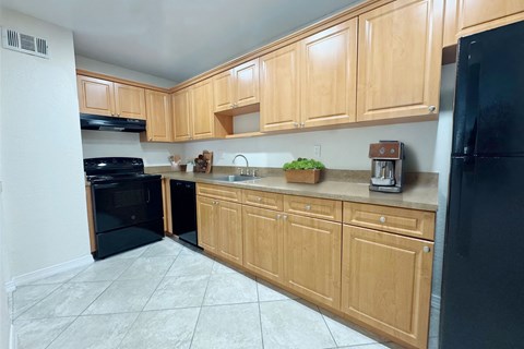 a kitchen with black appliances and wooden cabinets