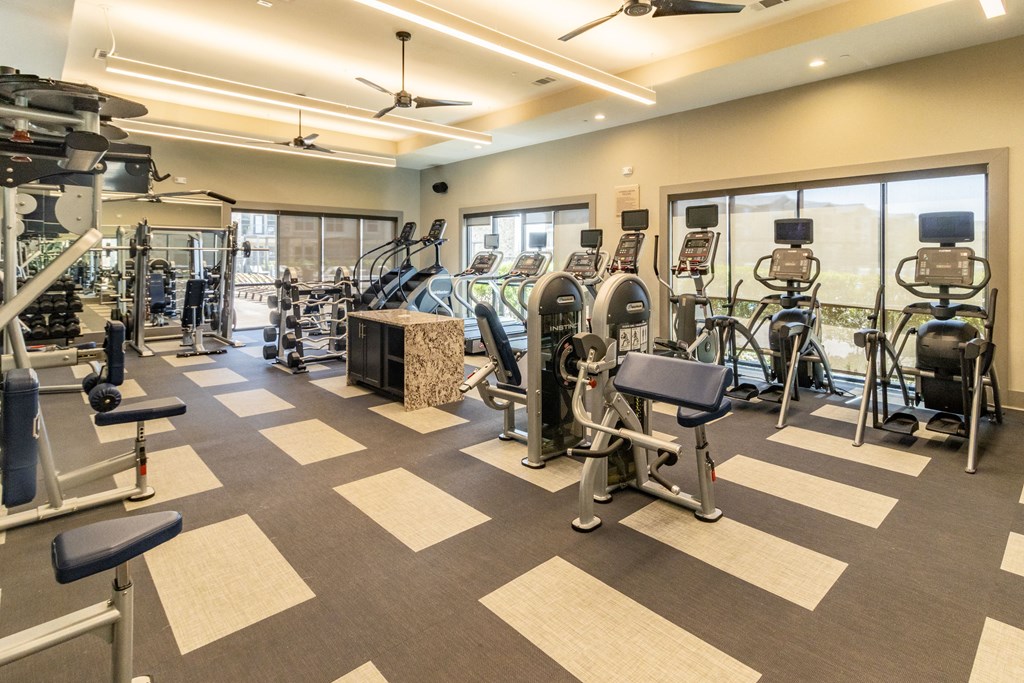 a spacious fitness center with cardio machines and other exercise equipment