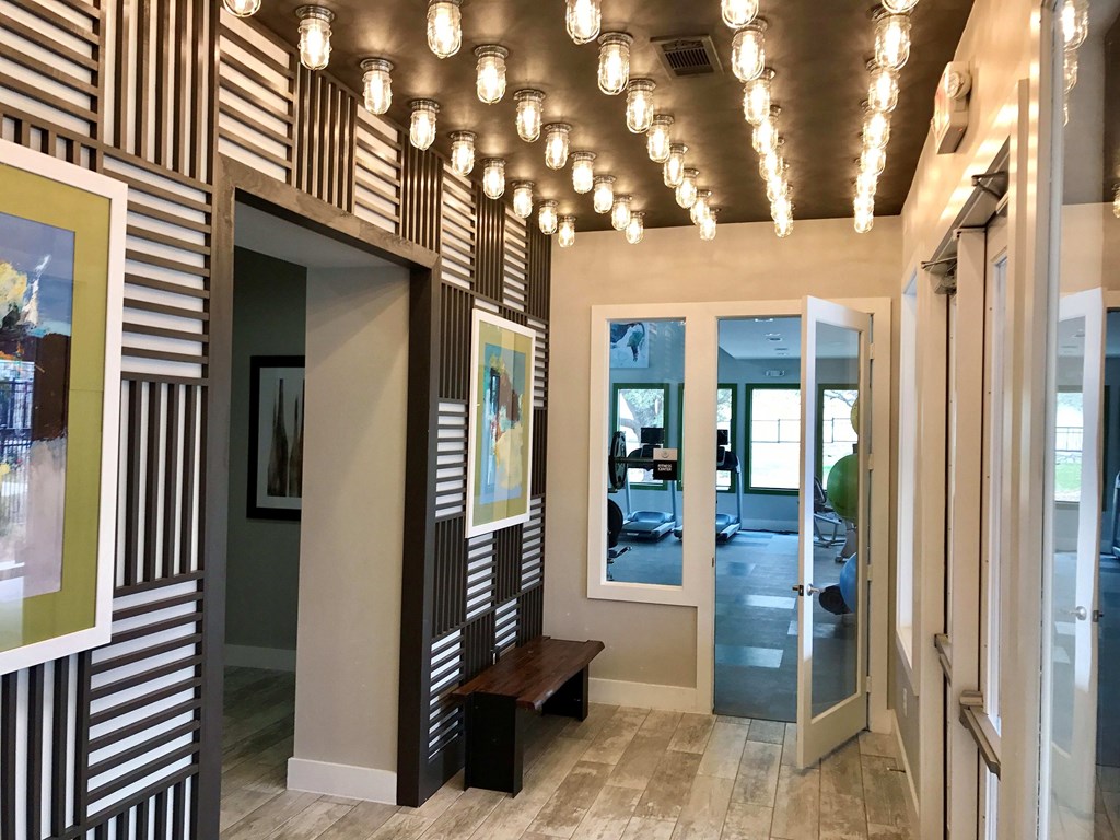 A hallway with a bench and a painting on the wall.