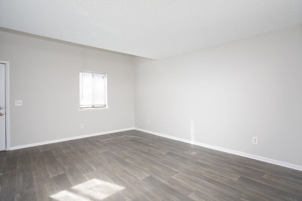 a bedroom with hardwood floors and white walls