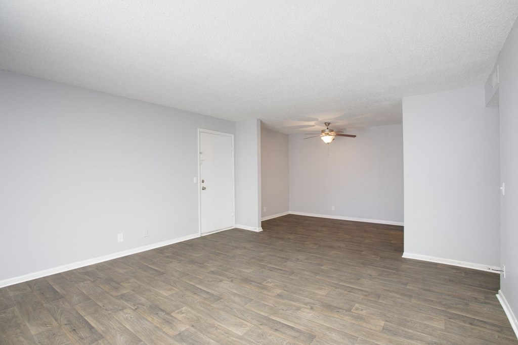an empty living room with a ceiling fan