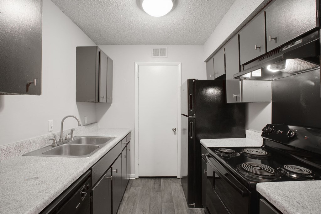 a kitchen with black appliances and white countertops