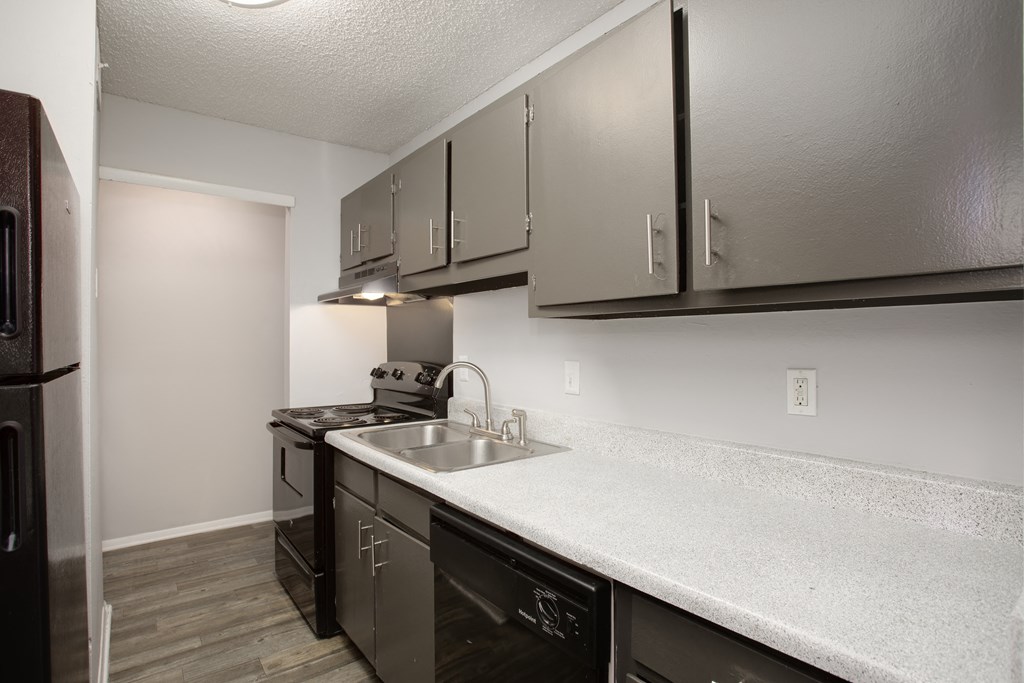 a kitchen with grey cabinets and a white counter top