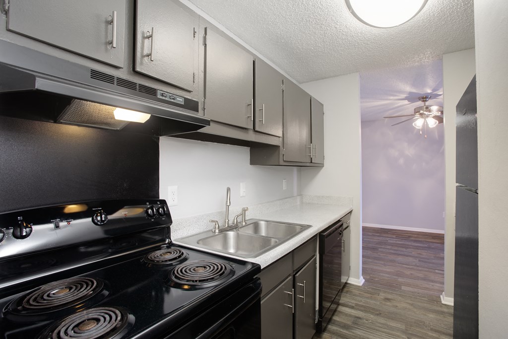 a kitchen with a stove top oven next to a sink