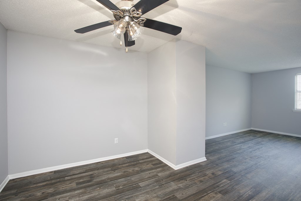 an empty room with a ceiling fan and a window