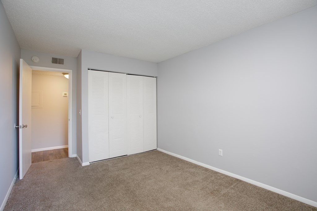 a bedroom with a closet and a door to a bathroom