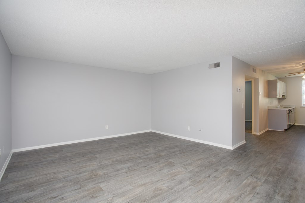 a bedroom with a hardwood floor and white walls
