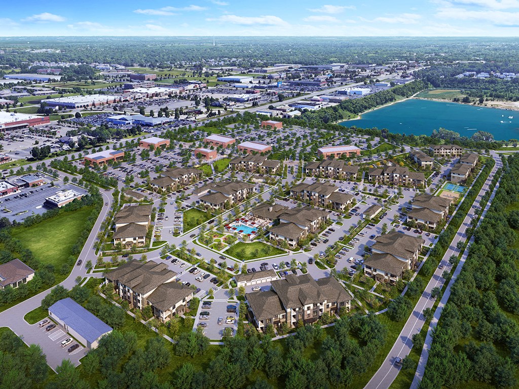 an aerial view of a city with houses and a body of water