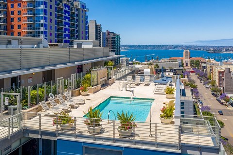 A rooftop pool area with a view of the city and water.