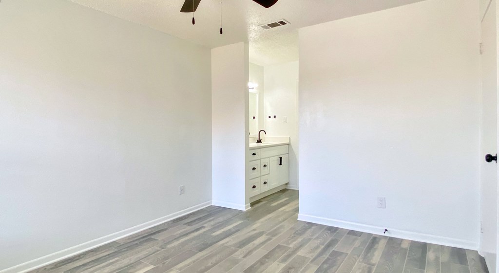 an empty living room with white walls and wood flooring