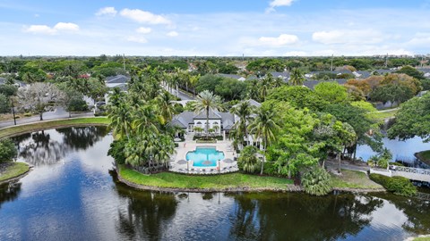 A house with a pool is surrounded by water and trees.