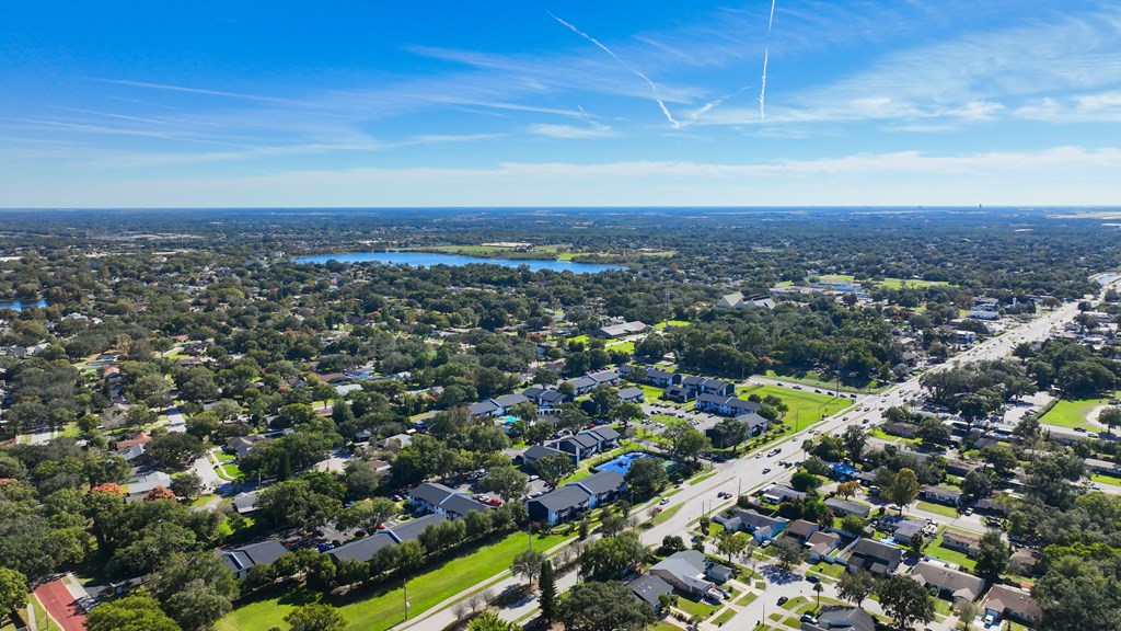 an aerial view of a city with houses and a lake