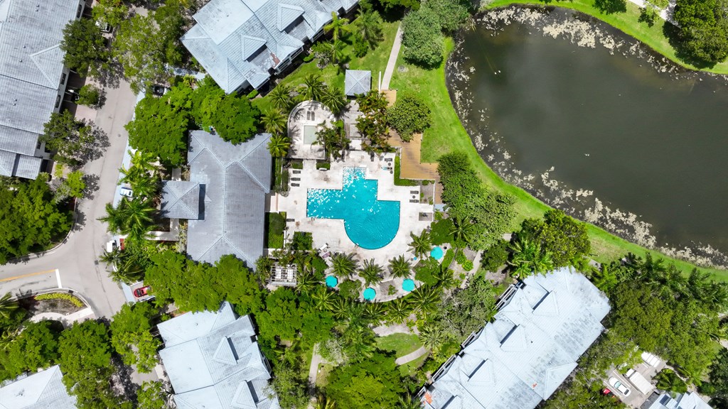 arial view of a swimming pool in the middle of a yard with trees and
