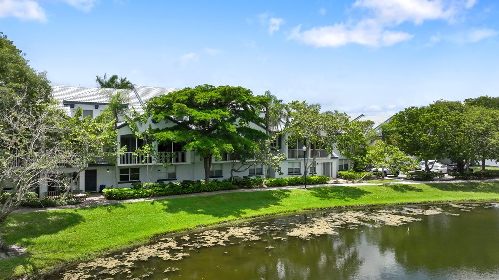 an apartment building sits next to a body of water