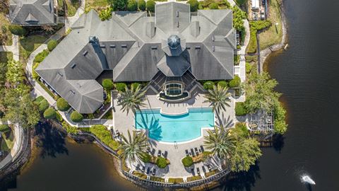 an aerial view of a house with a pool and palm trees