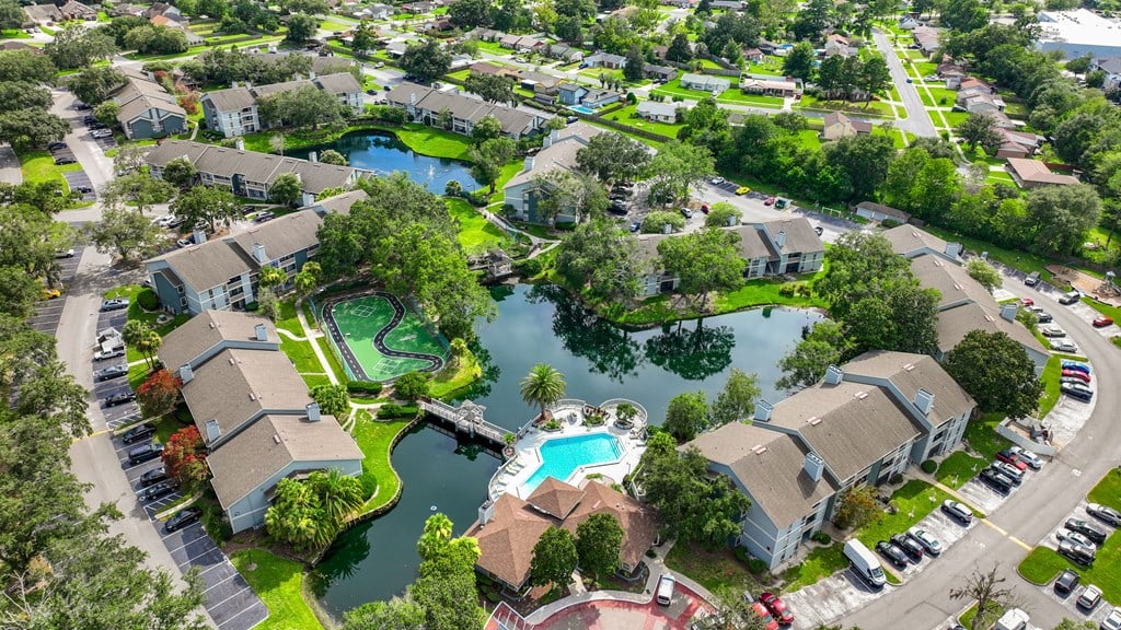an aerial view of the resort style community with a swimming pool and tennis court