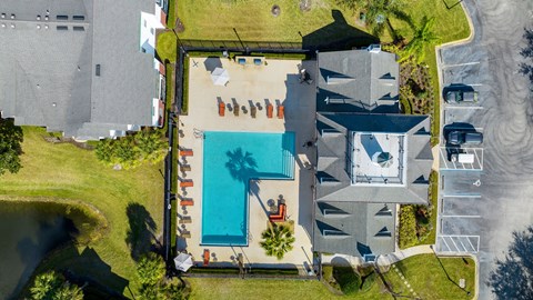 arial view of a house with a swimming pool and a yard with a beach
