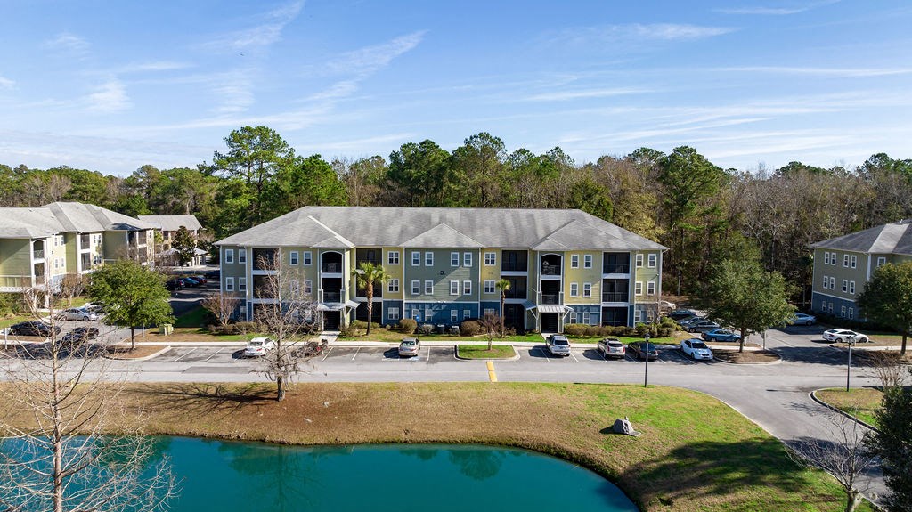 A large apartment complex with a pond in front.