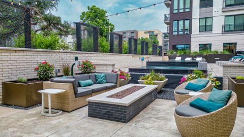 an outdoor patio with couches and a firepit