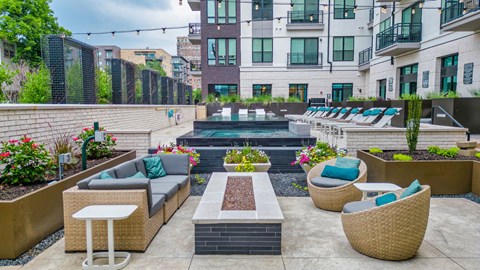 a patio with couches and chairs and a pool in the middle of a building
