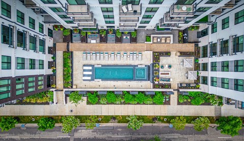 a birdseye view of a building with a swimming pool in the middle of it