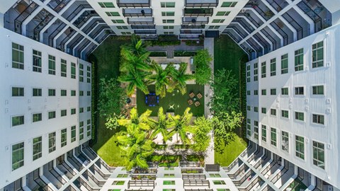 an aerial view of a courtyard in a building with trees and plants